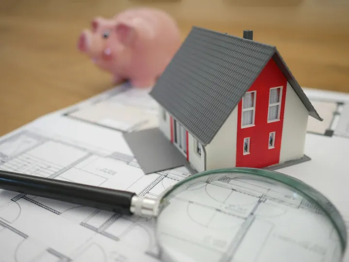 Loupe sur une maison et une tirelire
