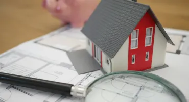 Loupe sur une maison et une tirelire