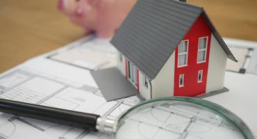 Loupe sur une maison et une tirelire
