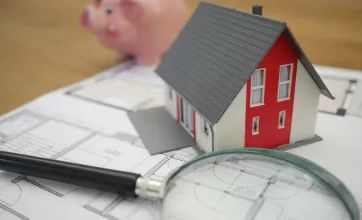Loupe sur une maison et une tirelire
