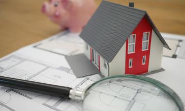 Loupe sur une maison et une tirelire